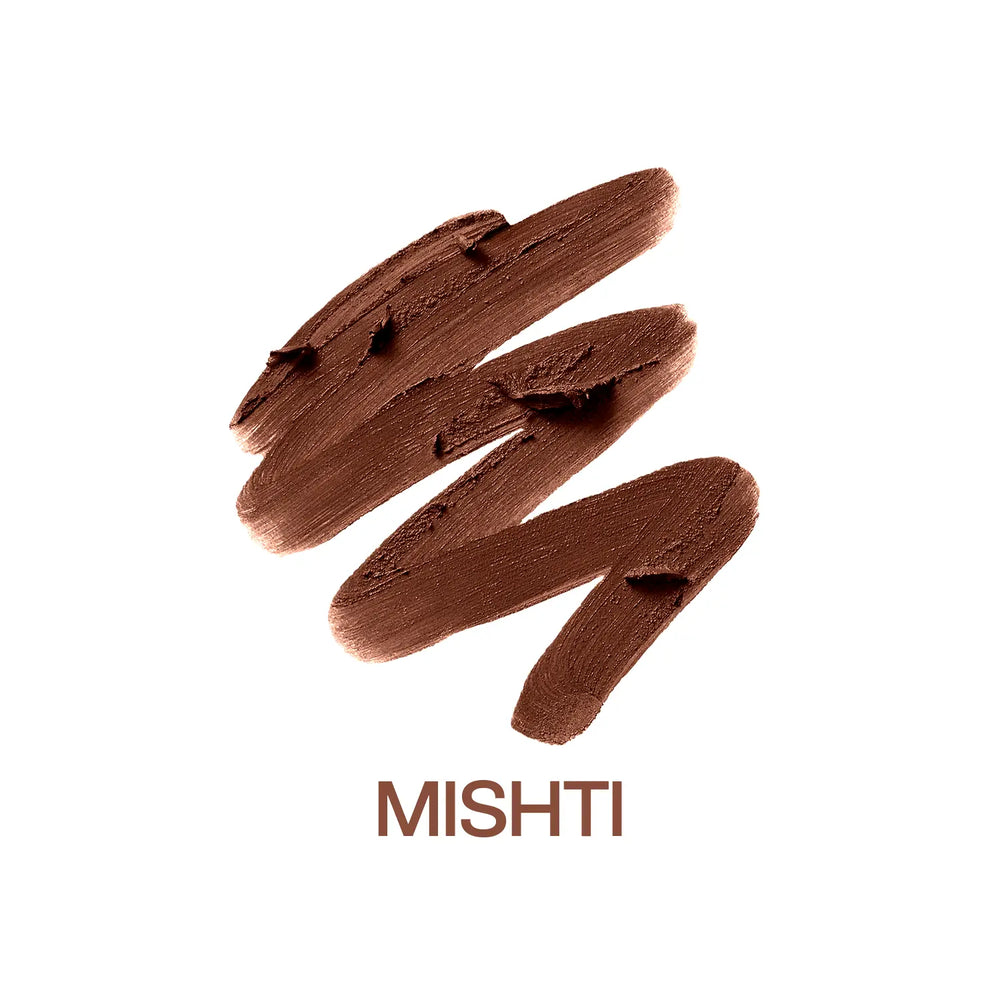 Macro close-up of MyHues Smudgestix Mishti cool nude brown lipstick gliding over rich creamy pigment. Soft matte bullet lipstick with one-swipe colour payoff, buildable coverage, smooth application, and a blendable lip and cheek formula for everyday wear.