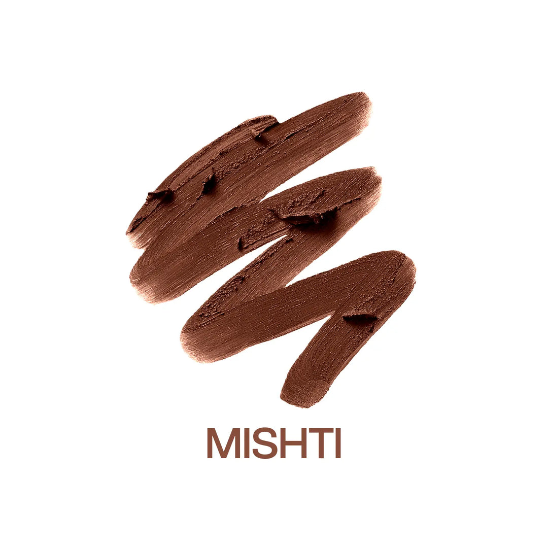 Macro close-up of MyHues Smudgestix Mishti cool nude brown lipstick gliding over rich creamy pigment. Soft matte bullet lipstick with one-swipe colour payoff, buildable coverage, smooth application, and a blendable lip and cheek formula for everyday wear.