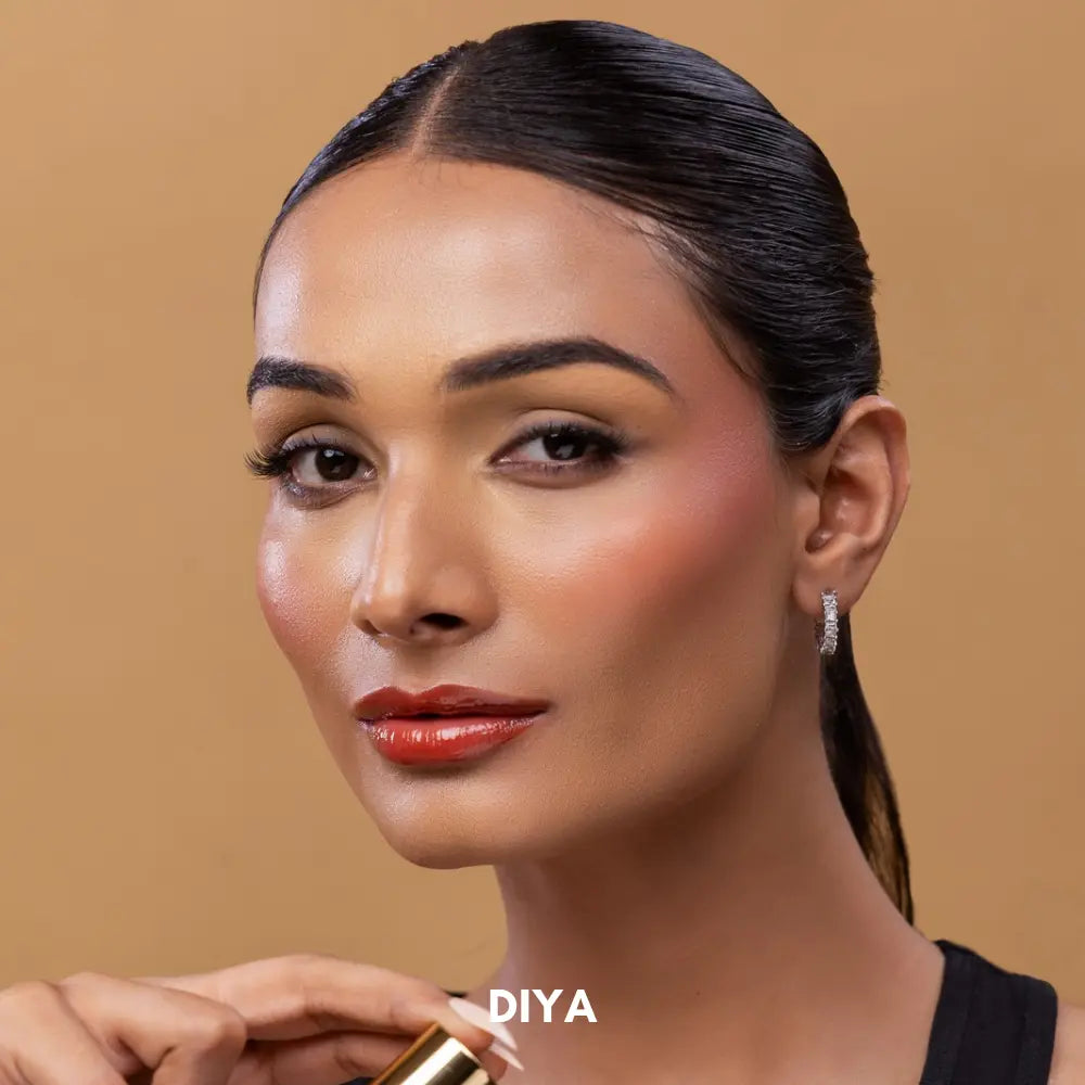 Indian model with dusky Indian skin tone wearing MyHues HyGlow Lip Elixir in Diya, a warm terracotta brown glossy lip oil and lip gloss hybrid. The vibrant earthy shade delivers high pigment, glass-like shine and even coverage on pigmented lips while complementing warm Indian skin tones.