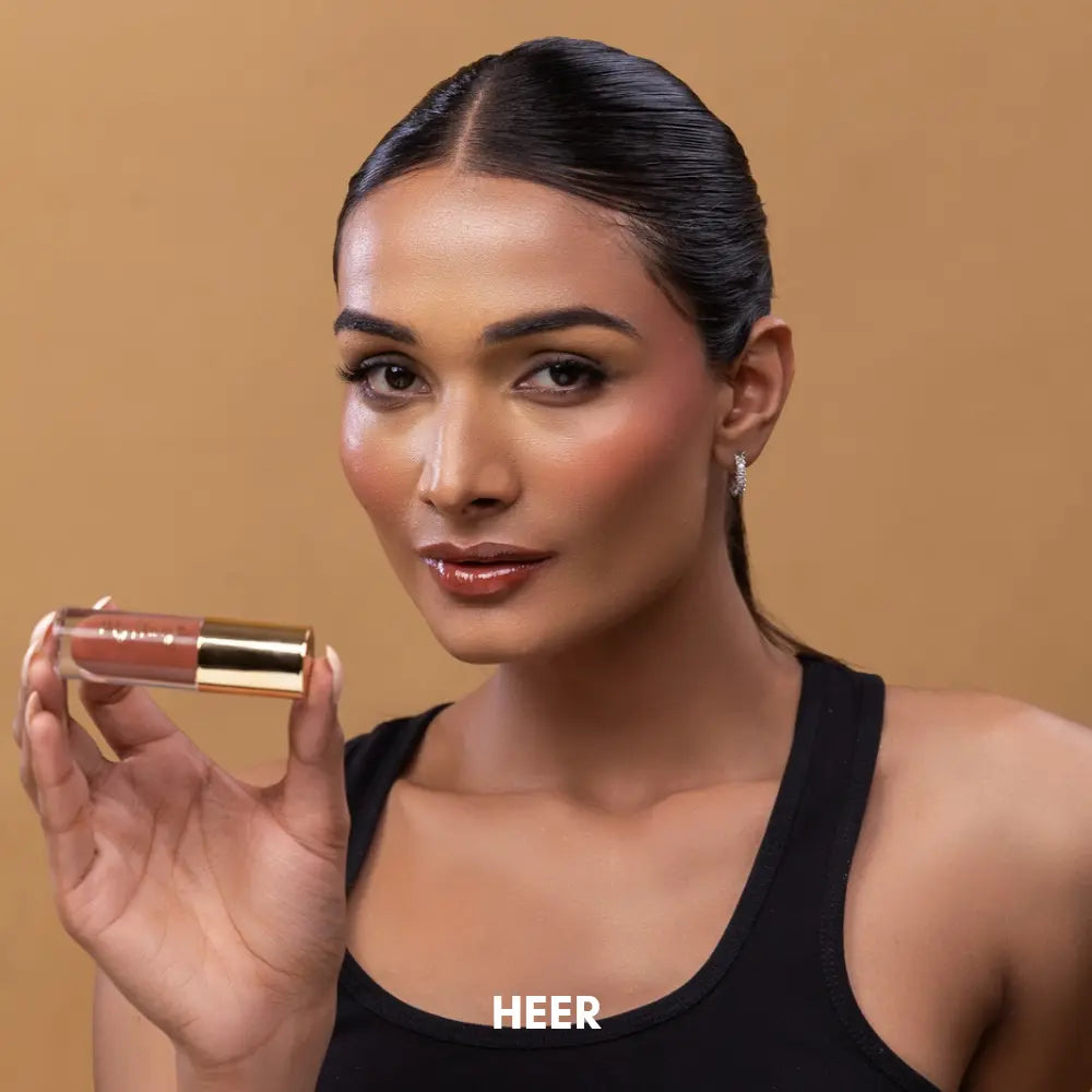 Indian model with dusky Indian skin tone wearing MyHues HyGlow Lip Elixir in Heer, a nude brown high-shine lip gloss and lip oil hybrid. The flattering nude brown shade gives lips a naturally polished look with rich pigmentation, glossy shine and a lightweight non-sticky finish designed for Indian complexions.
