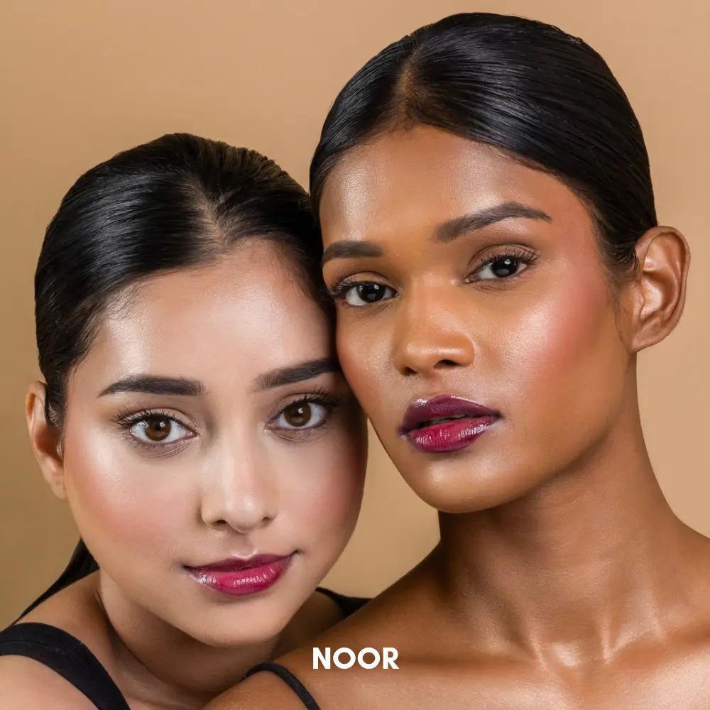 Indian model with dusky Indian skin tone wearing MyHues HyGlow Lip Elixir in Noor, a deep burgundy high-shine lip gloss and lip oil hybrid. The rich wine-toned shade delivers intense pigmentation, glass-like shine and even coverage on pigmented lips while complementing medium, tan and deep Indian skin tones with a bold, luxurious glossy finish.