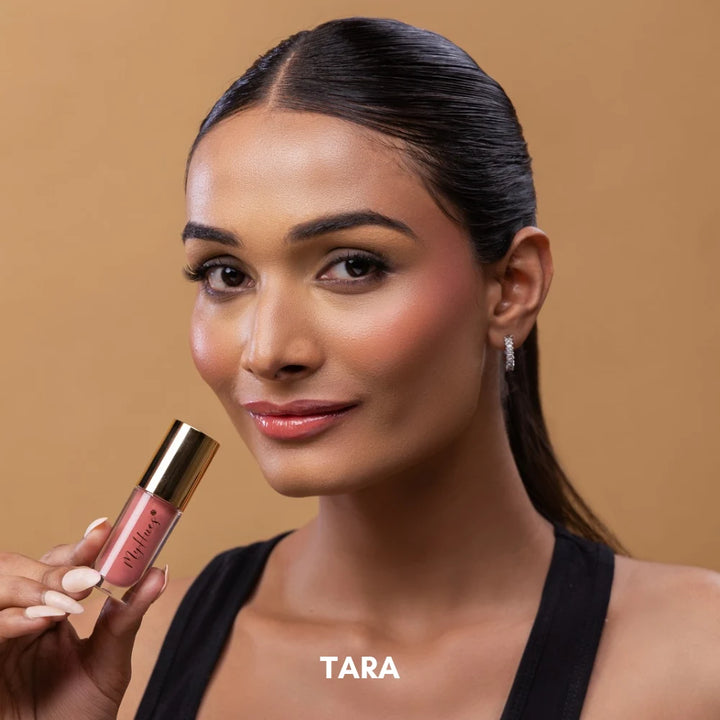 Indian model with dusky Indian skin tone wearing MyHues HyGlow Lip Elixir in Tara, a soft nude pink high-shine lip gloss and lip oil hybrid. The delicate nude pink shade adds glossy colour, lightweight hydration and a smooth non-sticky finish while beautifully complementing dusky Indian skin and naturally pigmented lips.
