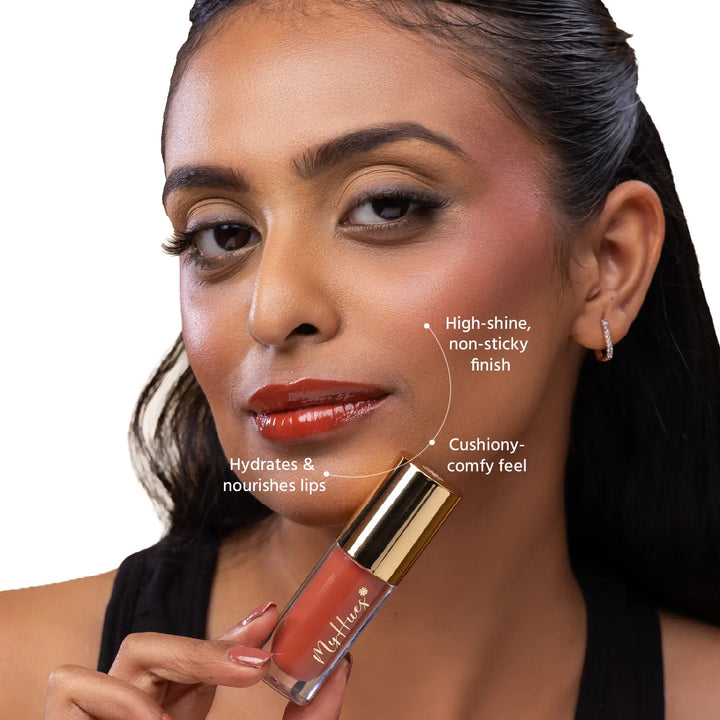 Close-up of an Indian model wearing MyHues HyGlow Lip Elixir Diya, a warm terracotta brown glossy lip oil and lip gloss hybrid. High-shine, non-sticky formula hydrates and nourishes lips while delivering a cushiony feel and rich terracotta brown colour that helps cover dark or pigmented lips.
