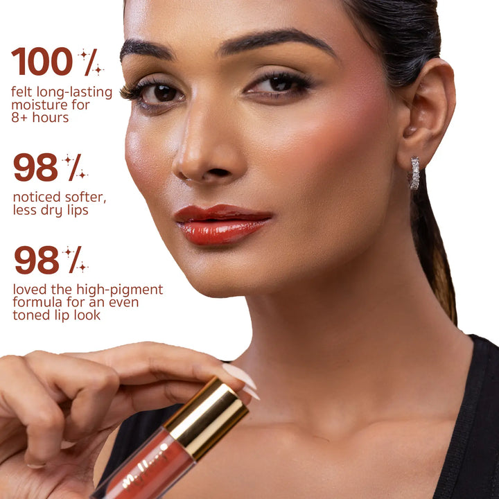 Indian model applying MyHues HyGlow Lip Elixir Diya, a warm terracotta brown high-shine lip oil and lip gloss. Consumer-tested results show 100% experienced long-lasting moisture for over 8 hours, 98% noticed softer lips, and 98% loved the highly pigmented formula for an even-toned lip look.