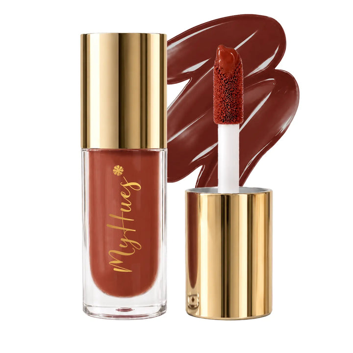 MyHues HyGlow Lip Elixir Heer nude brown lip oil and lip gloss featuring premium gold packaging, plush doe-foot applicator and glossy nude brown swatch. Highly pigmented lip gloss with nourishing oils provides mirror-like shine, lightweight comfort and flattering colour for Indian skin tones.