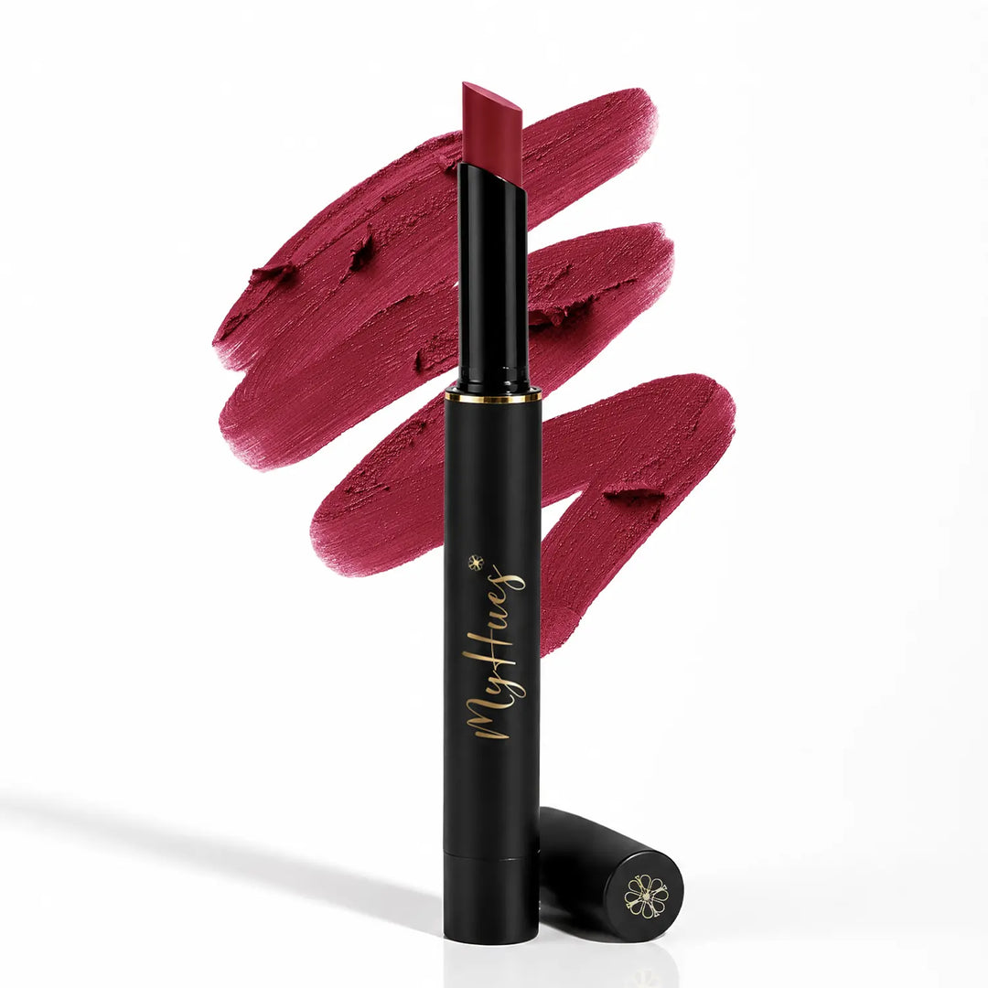 MyHues Smudgestix Sondesh soft matte lip and cheek stick standing upright with burgundy lipstick swatches in the background. Premium black and gold packaging highlighting the creamy, blendable bullet lipstick designed for lips and cheeks with long-lasting colour for Indian skin tones.